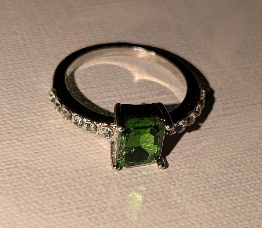 Silverfärgad ring med grön sten och strass