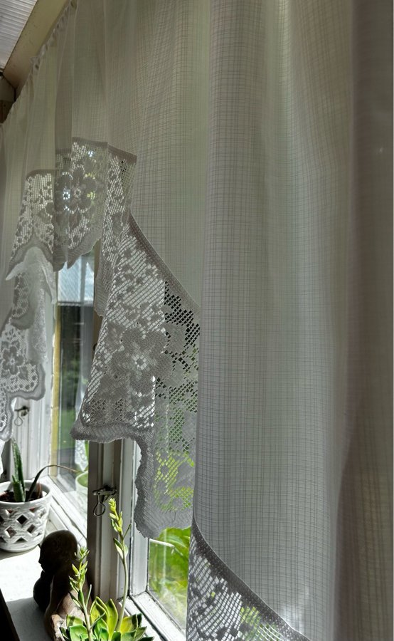 Syntetisk gardin med vacker mönstrad bred spets i vit färg