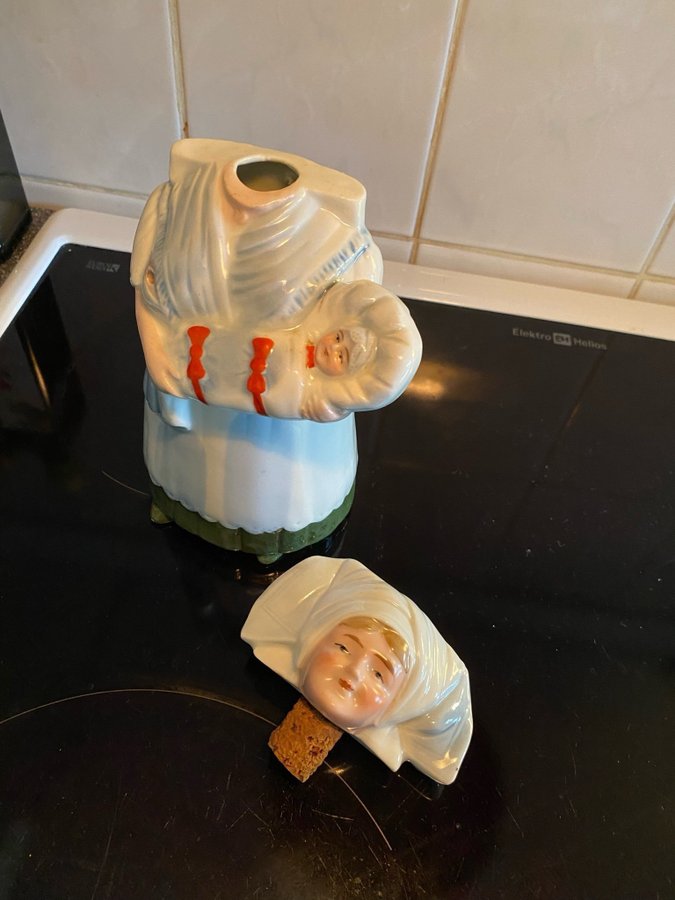 Fin gammal likör flaska i keramik med huvud som korksjuksköterska med spädbarn