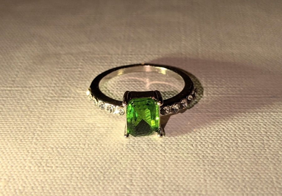 Silverfärgad ring med grön sten och strass