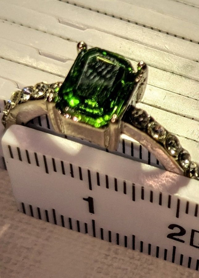 Silverfärgad ring med grön sten och strass