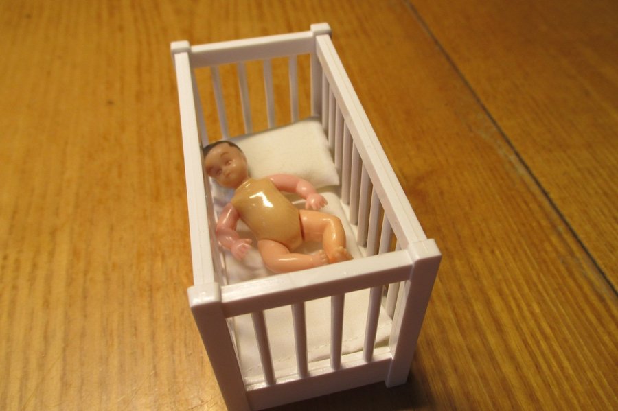 Dockmöbler: Spjälsäng med bebis i plast