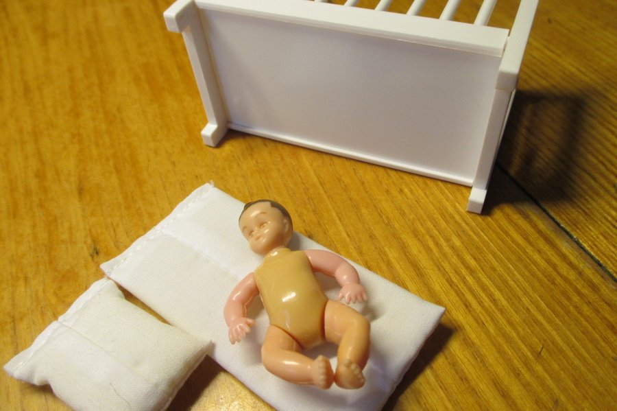 Dockmöbler: Spjälsäng med bebis i plast
