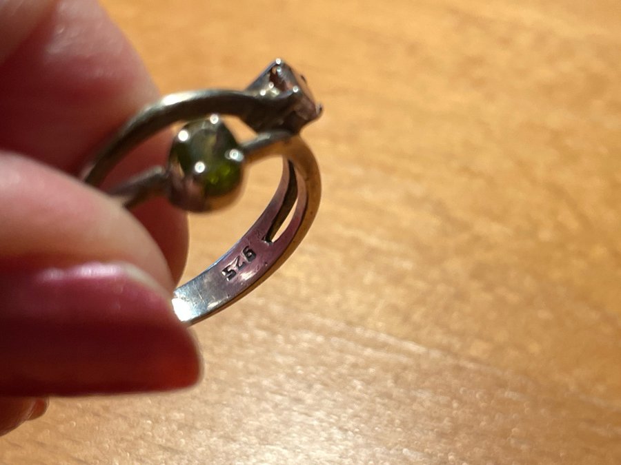 En ring i silver med 2 stenar en rosa och en grön storlek ca 18