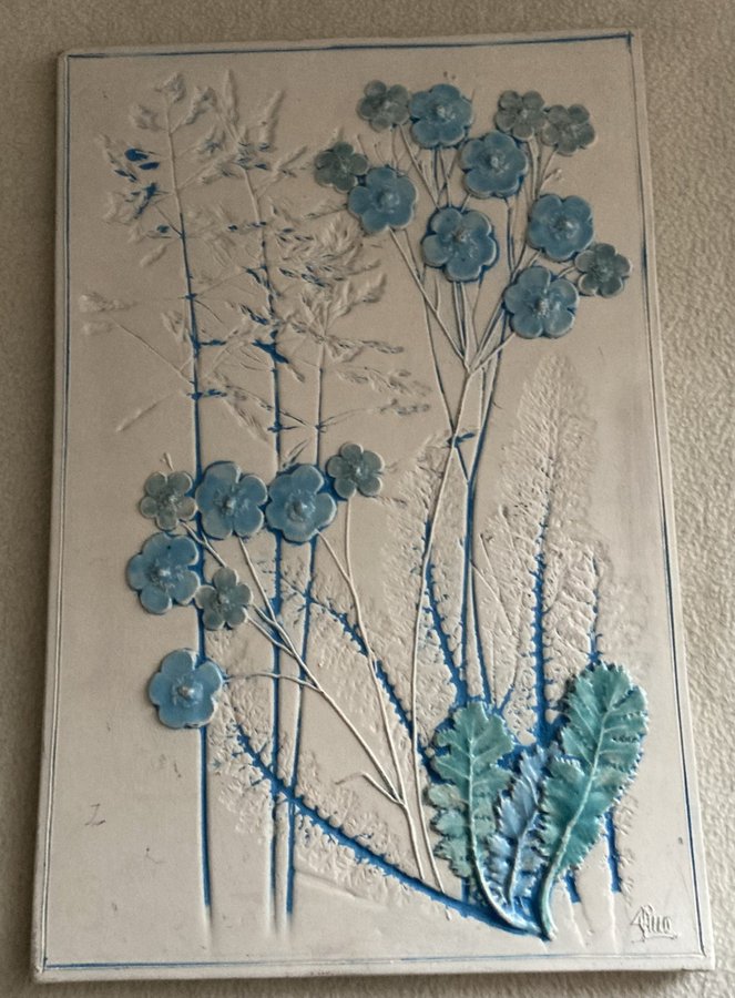 Stor Väggplatta med blå blommor signerad Aimo från Jie mått 21 x 31 cm.