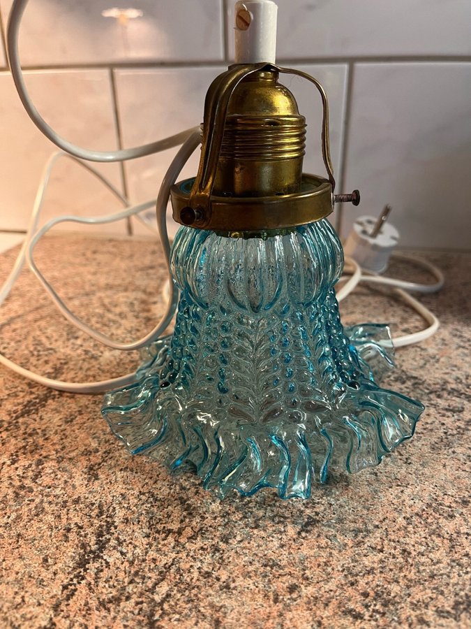 Äldre fönsterlampa i blått glas.