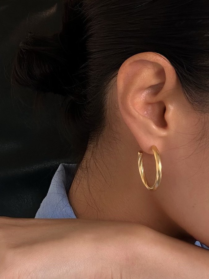 Hoops i stål med 18k guld med tvinnad design