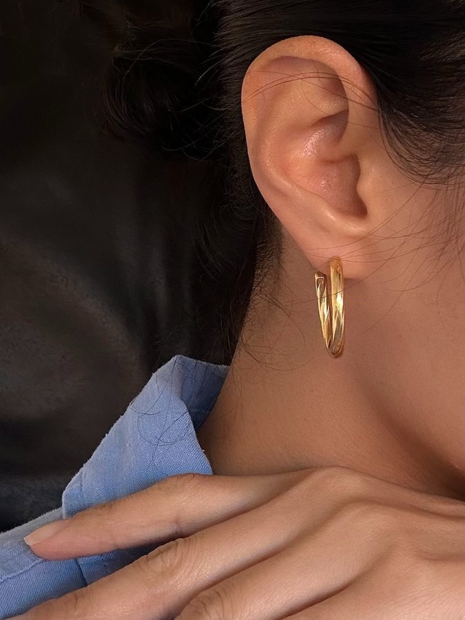 Hoops i stål med 18k guld med tvinnad design