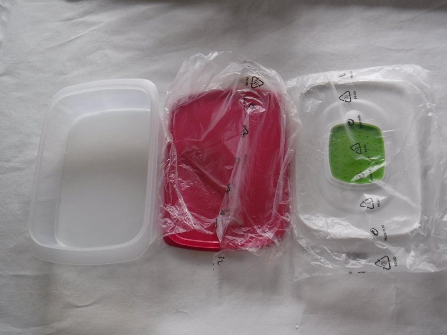 Oanvänd Tupperware burk med ett rosa lock samt ett lock med galler för fukt