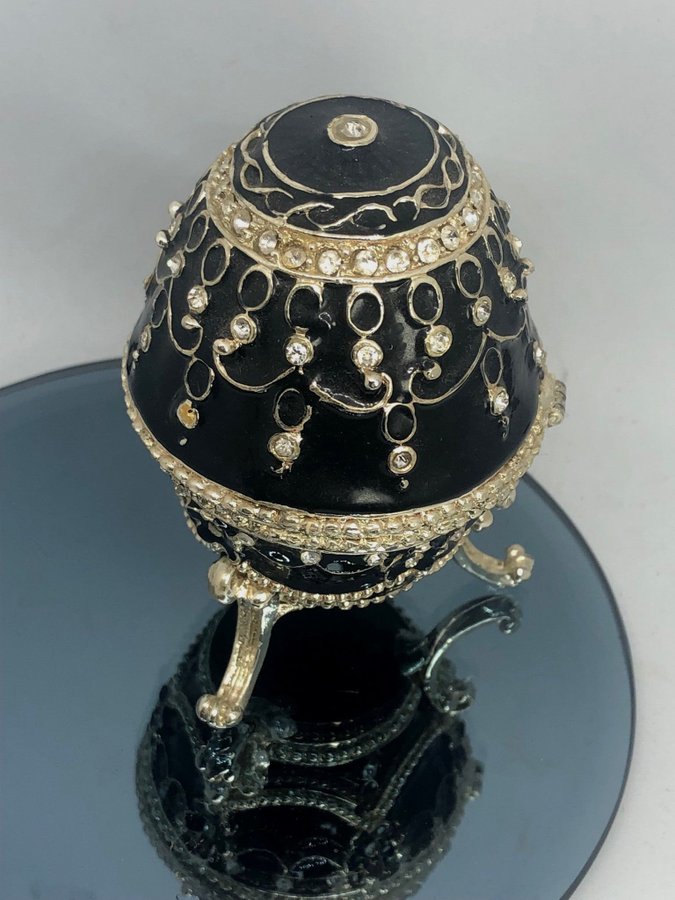 Svart äldre faberge-egg gulddetaljer och gnistrande stenar emalj