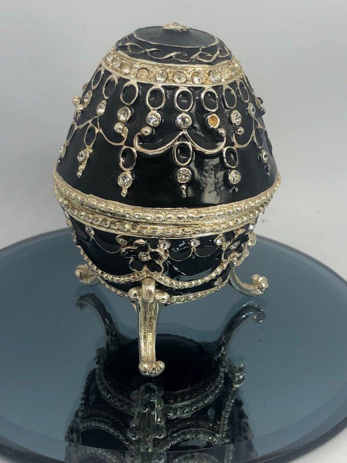 Svart äldre faberge-egg gulddetaljer och gnistrande stenar emalj