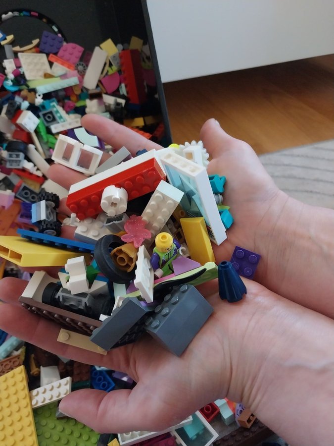 Lego bitar i olika färger och former i LEGO låda