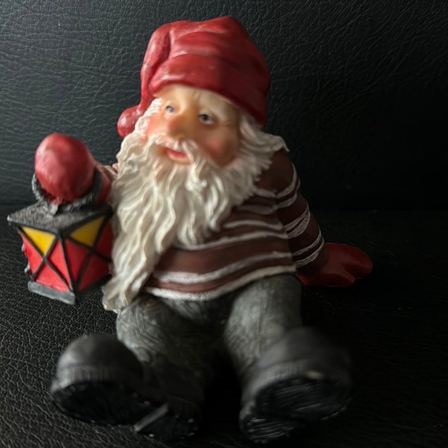 Tomte sittande och tomtemor på kälke