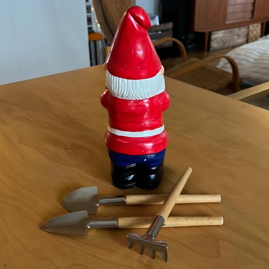 Äldre tomte med trädgårdsredskap