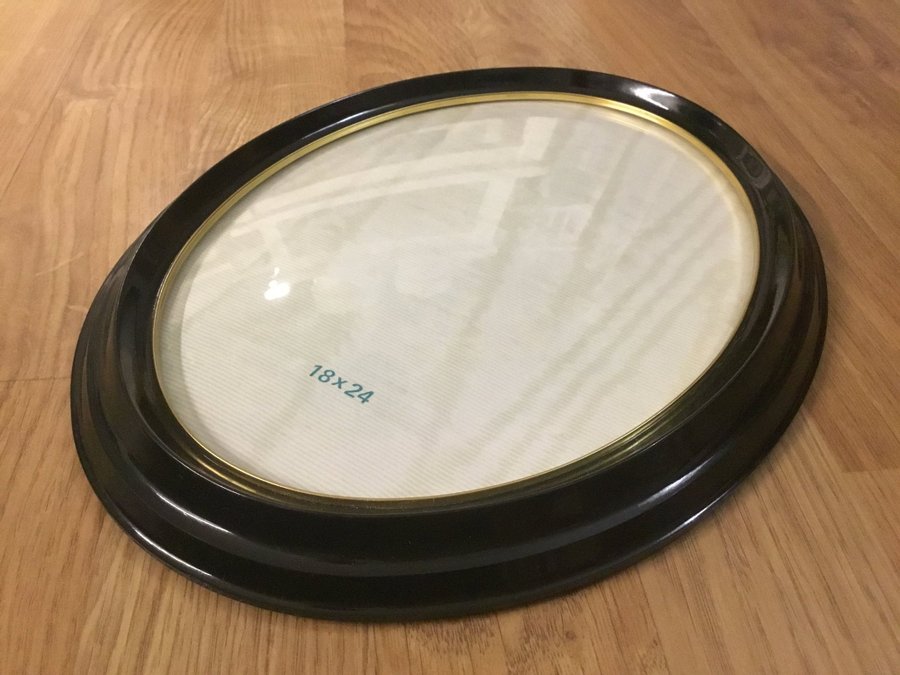 Klassisk oval retro ram, fotoram i svart Bakelit med kupat glas  guldkant