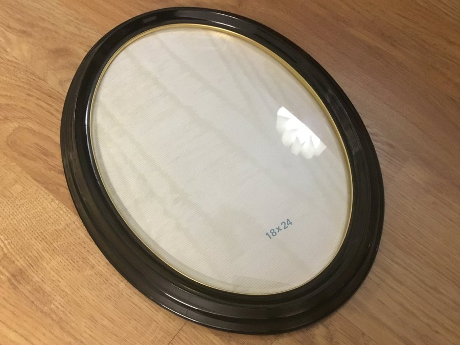 Klassisk oval retro ram, fotoram i svart Bakelit med kupat glas  guldkant