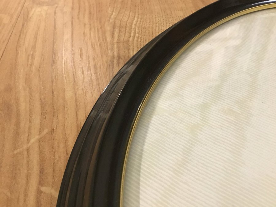 Klassisk oval retro ram, fotoram i svart Bakelit med kupat glas  guldkant