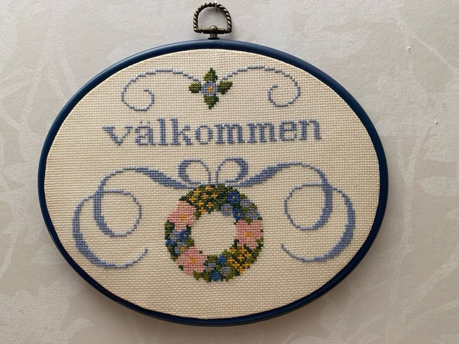 Broderad tavla.” Välkommen”.