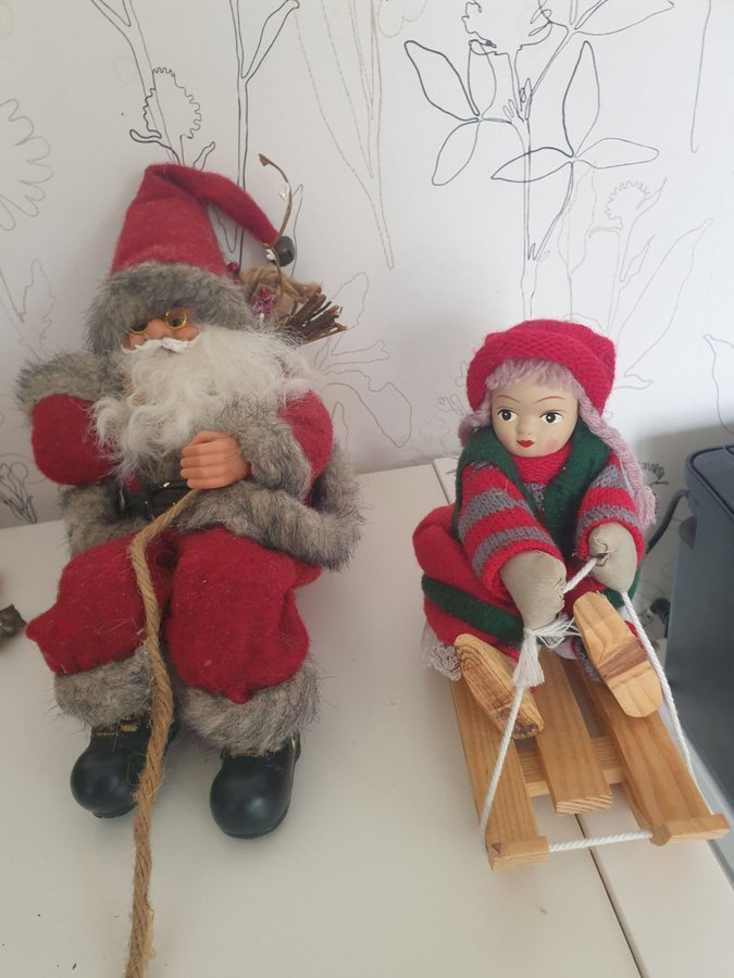 Jultomte och flicka på släde