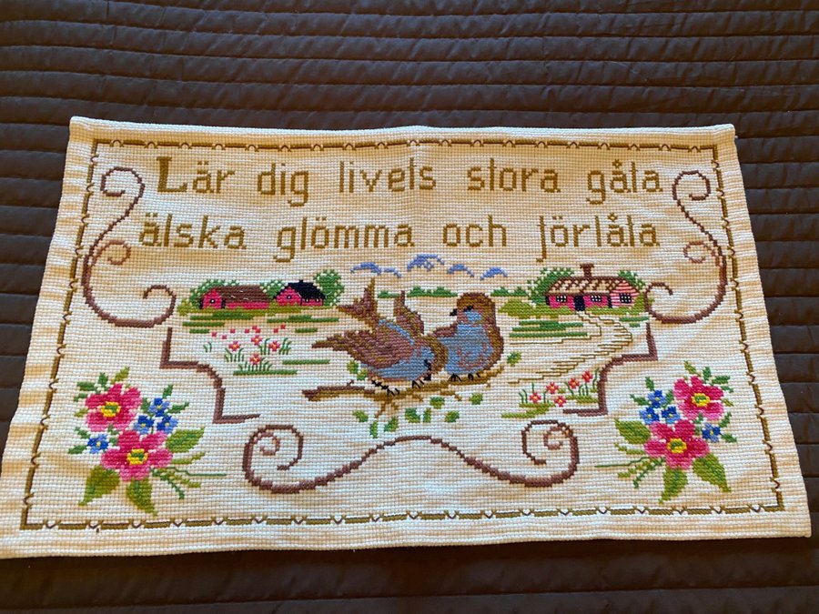 Broderad bonad med Texten " Lär dig livets stora gåta, älska glömma och förlåta”