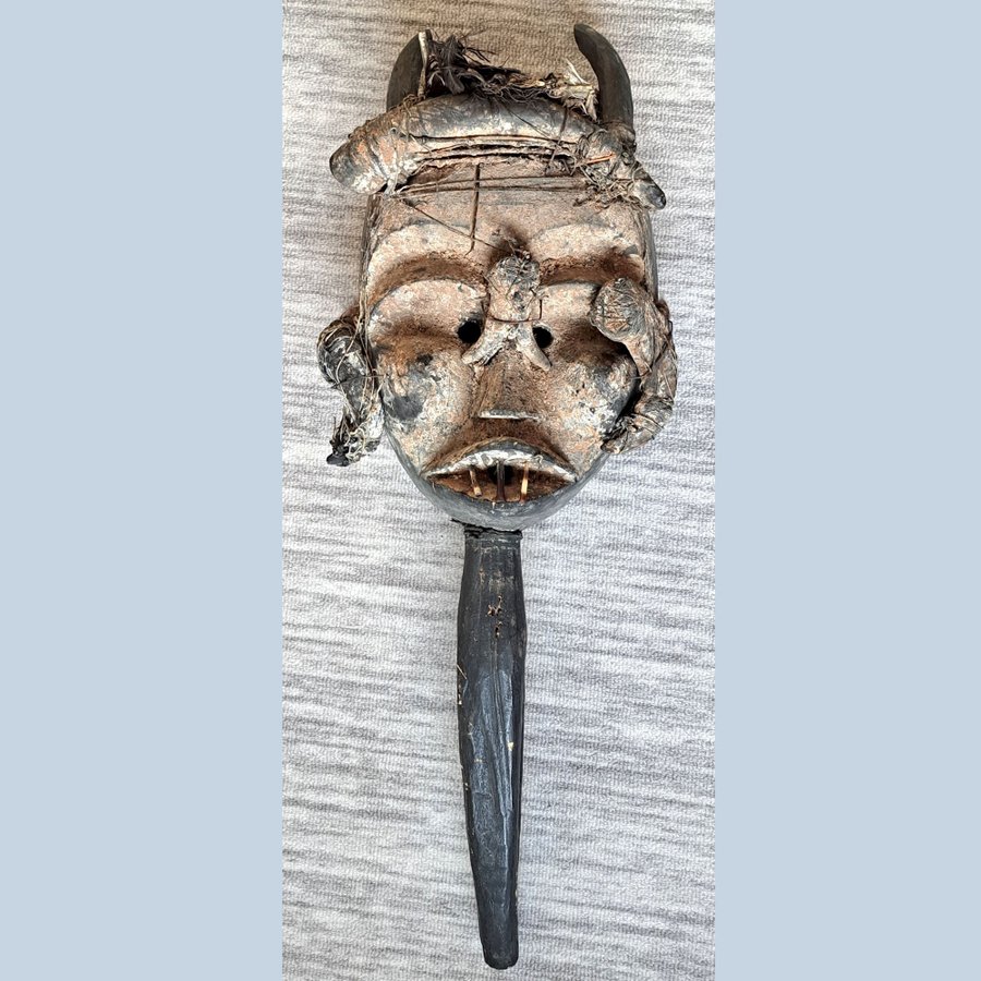 Afrikansk mask med horn och fjädrar. Retro konsthantverk.