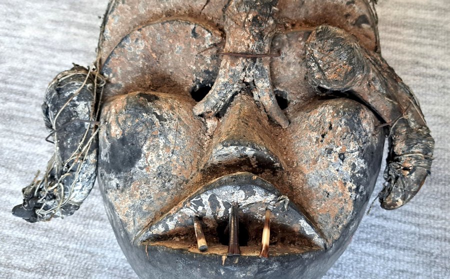 Afrikansk mask med horn och fjädrar. Retro konsthantverk.