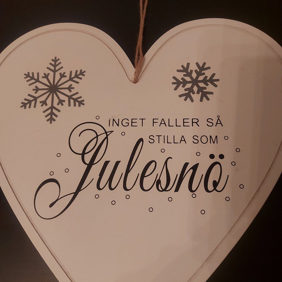 Hjärtformad juldekoration med texten "Inget faller så stilla som julesnö"