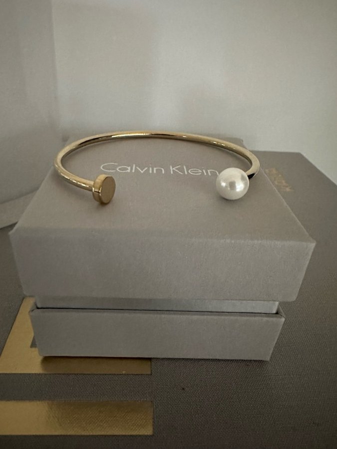 CALVIN KLEIN bangle/armring i stål med guldplätering och pärla