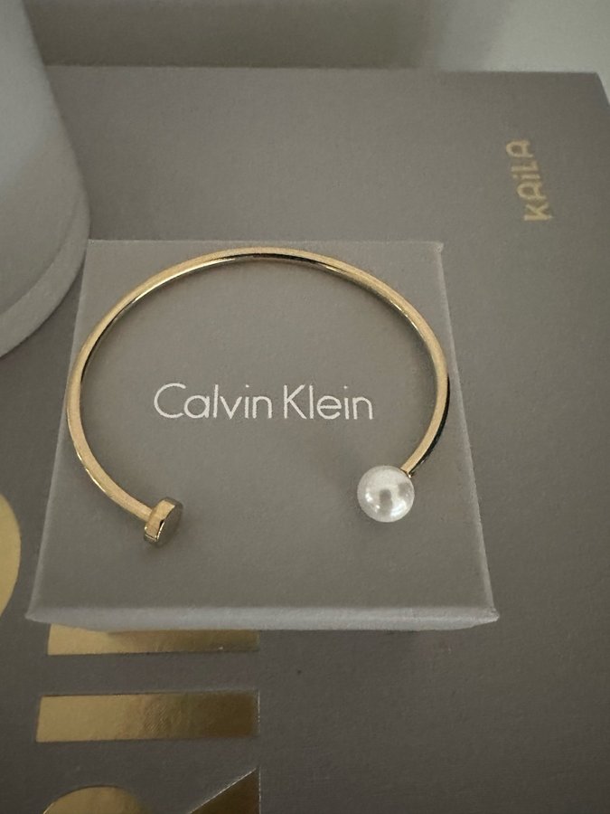 CALVIN KLEIN bangle/armring i stål med guldplätering och pärla