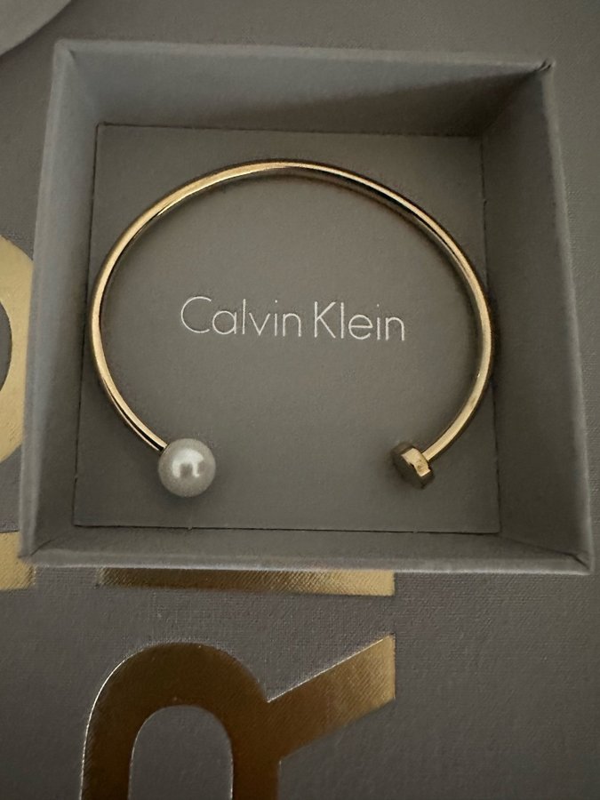 CALVIN KLEIN bangle/armring i stål med guldplätering och pärla