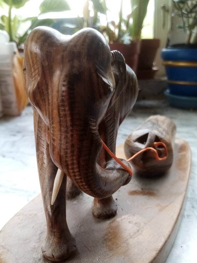 1 elefant som drar en stock i trä. 25 cm x 15 cm.