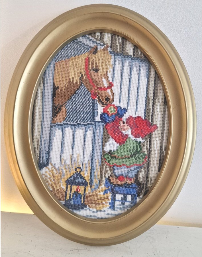 Broderad inramad tavla med tomte och häst