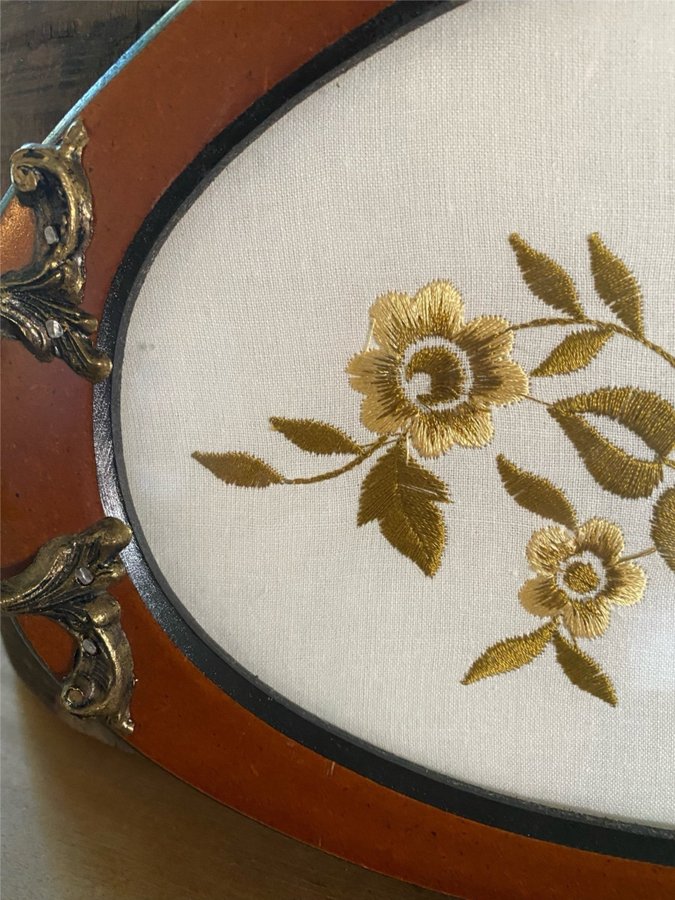 GAMMAL OVAL TRÄBRICKA MED BRODERI UNDER GLASSKIVA LANTLIG STIL