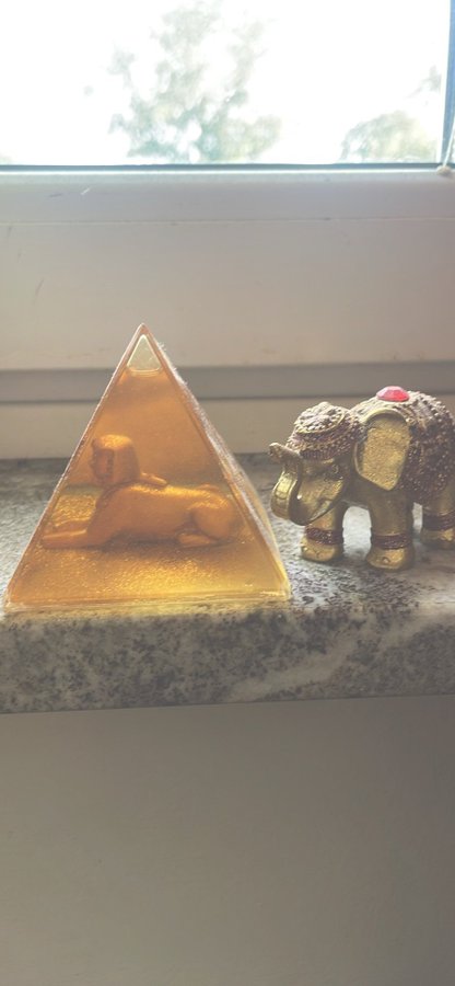 Pyramide med egyptisk figur och guld elefant