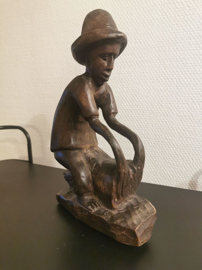 Stor skulptur av trä en man som spelar på trumma