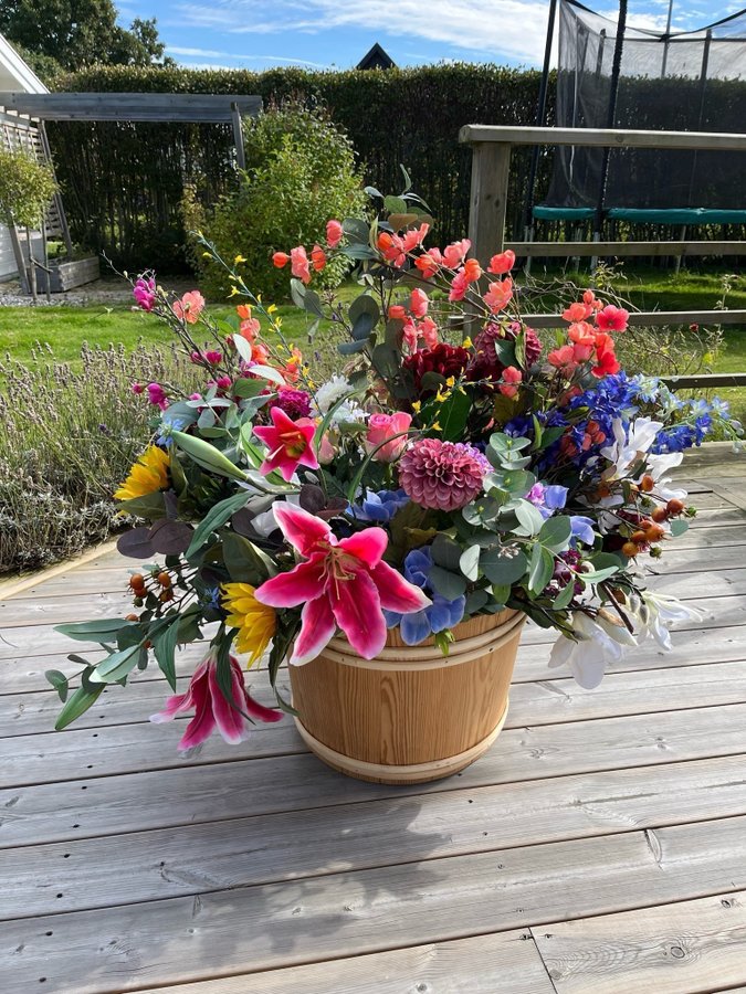 Konstgjord blomsterarrangemang i träfat