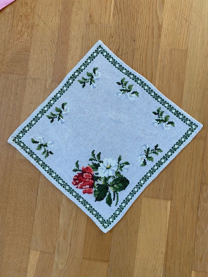 Söt liten broderad duk med blombukett