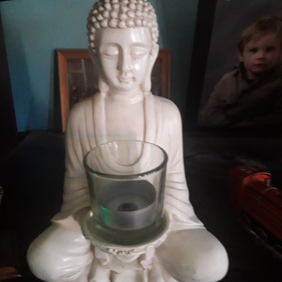 Buddhastaty med ljus