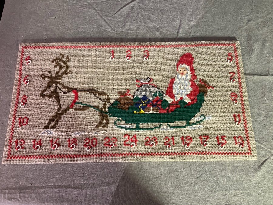 Broderad julkalender med korsstygn på tavla.