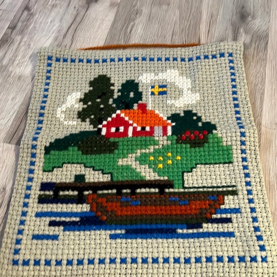 Svenskt broderi med hus och båt